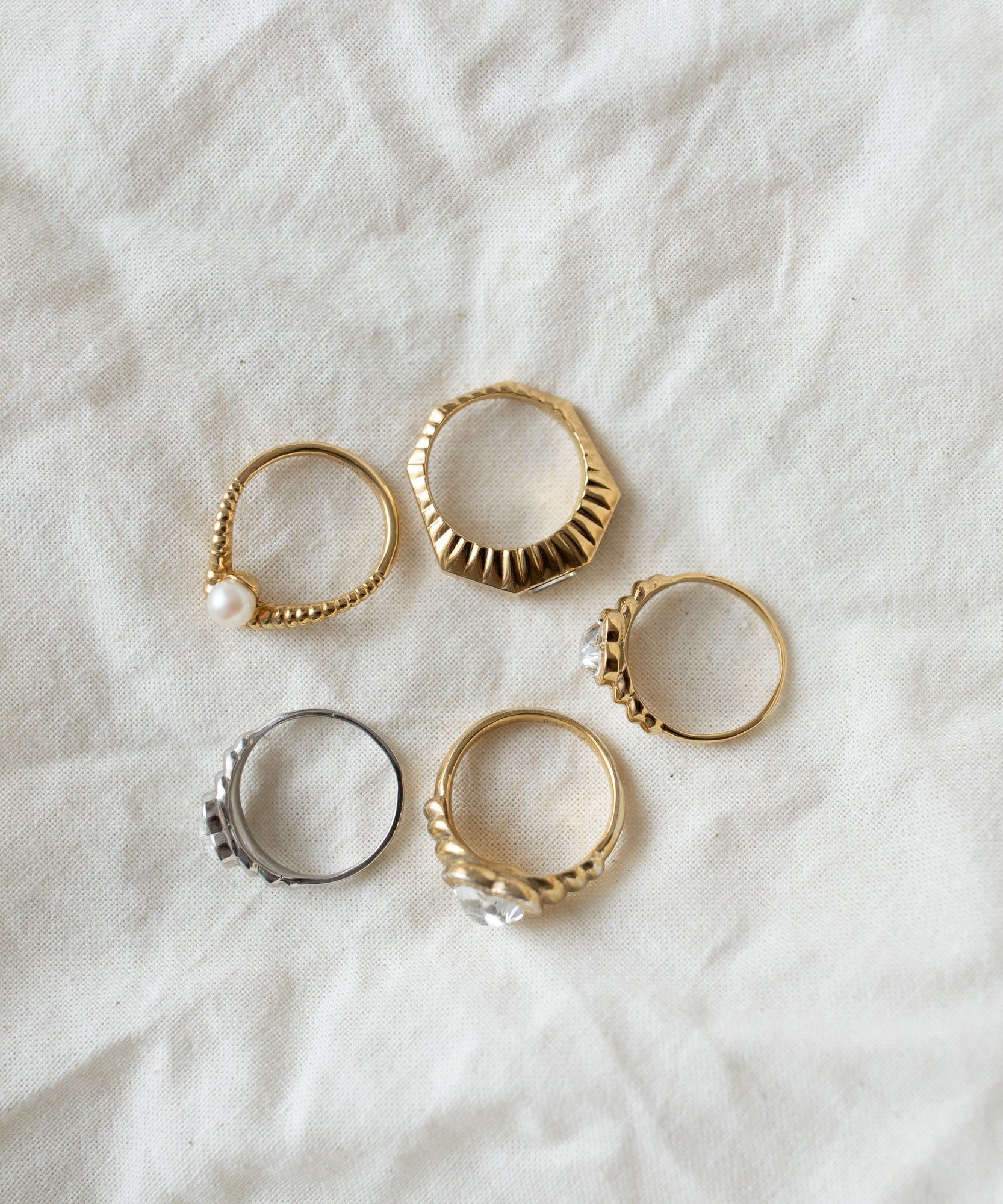 Six assorted Be My Lover Mini Silver Rings by WALD Berlin displayed on a textured white fabric.