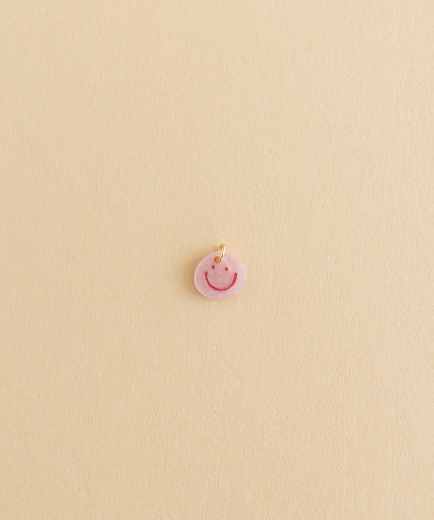 A small Smilie Dude Charm Rose by WALD World adorned with creole jewelry.