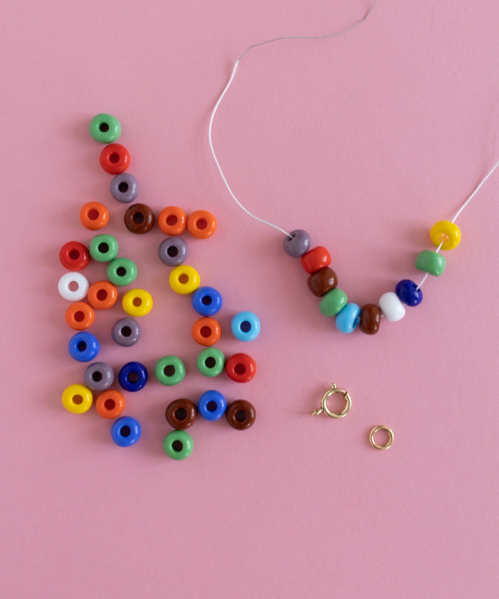 A DIY jewelry kit featuring a necklace and bracelet crafting set with colorful beads and a ring, presented on a pink background by WALD World.