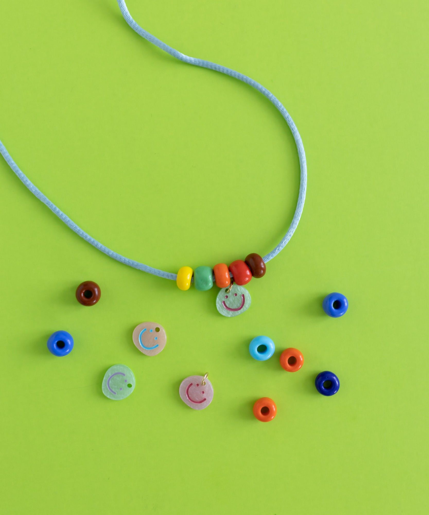 A colorful necklace adorned with beads and a smiley charm, perfect for jewelry enthusiasts.