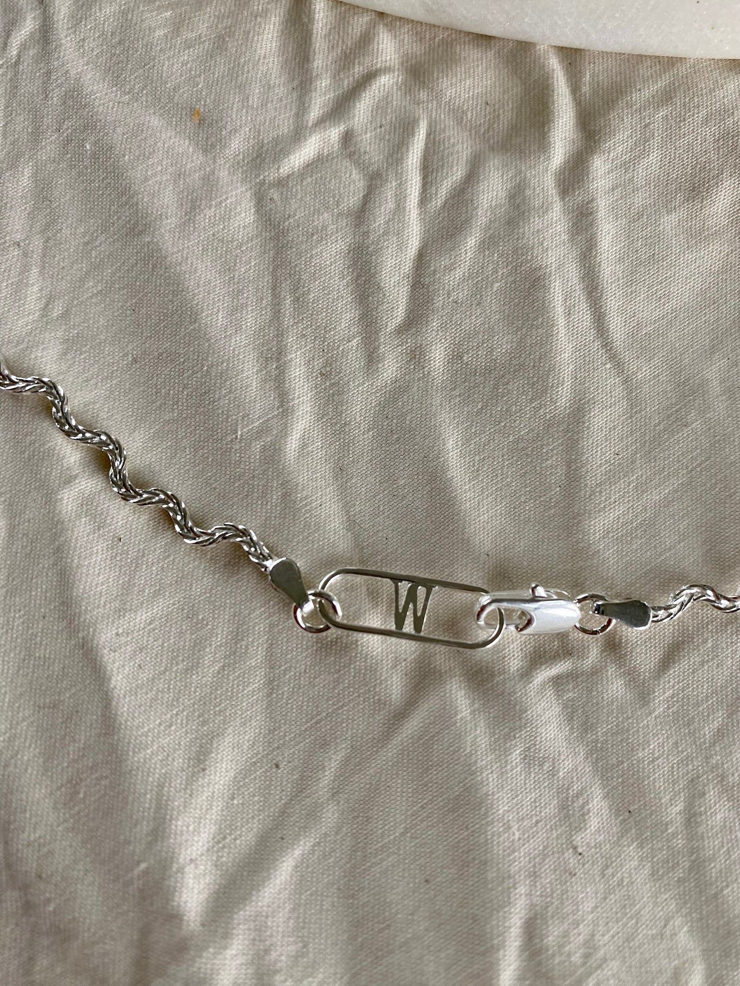 An Irina Necklace Silver with a letter on it made by WALD Berlin, a German family-run business.