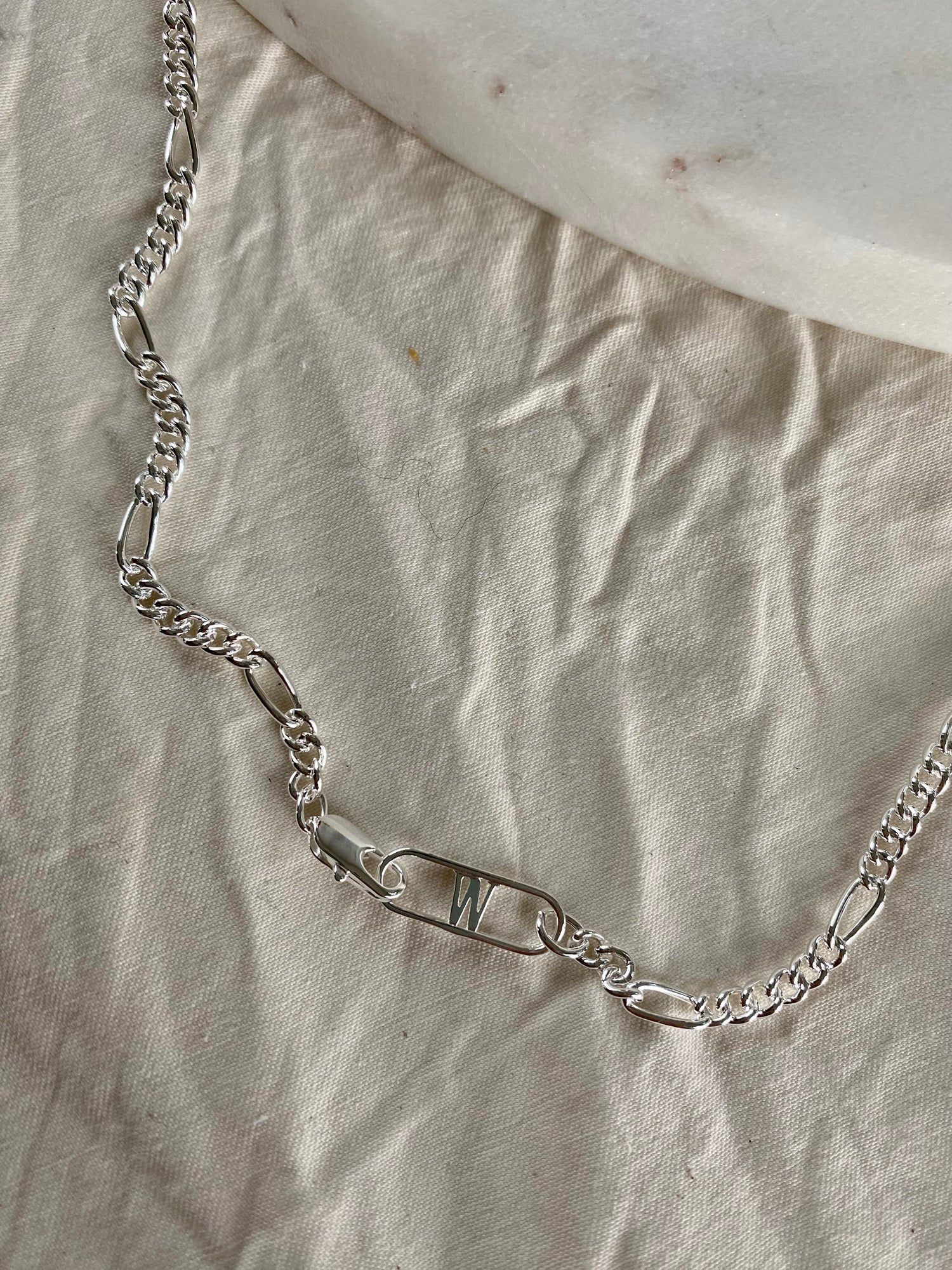 A Naomi Necklace Silver on a white surface, made by WALD Berlin, a German family-run business specializing in recycled 18k gold and silver.