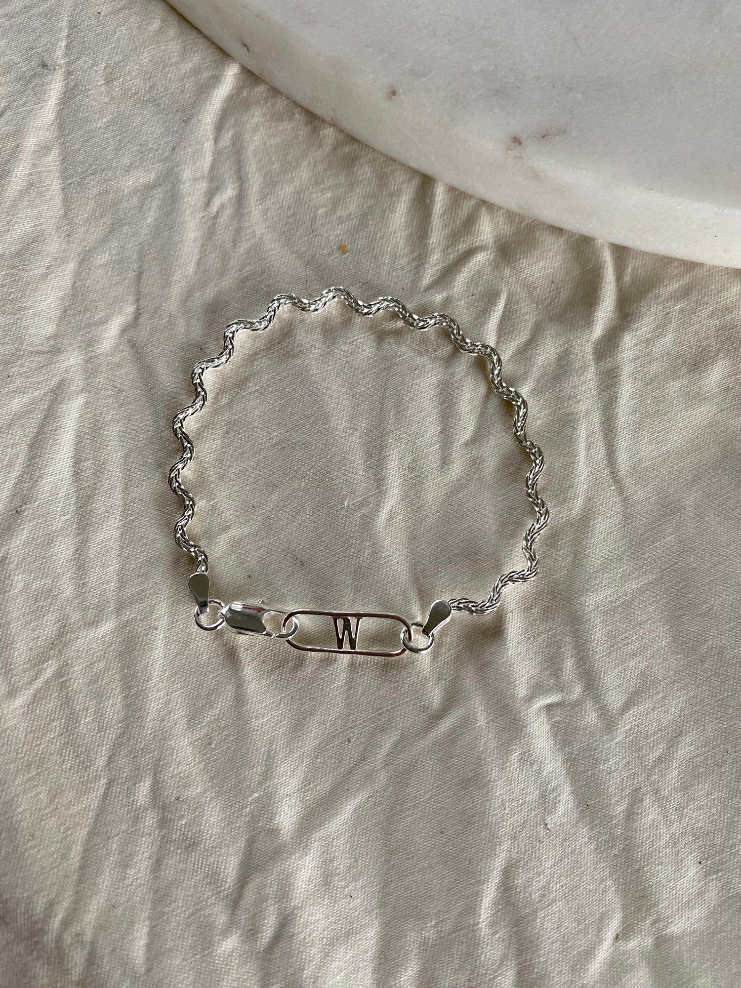 A WALD Berlin Irina Bracelet Silver with an initial on it.