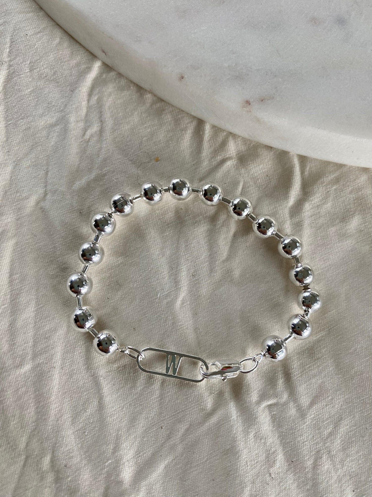 A WALD Berlin Harry Bracelet Silver on a marble table.