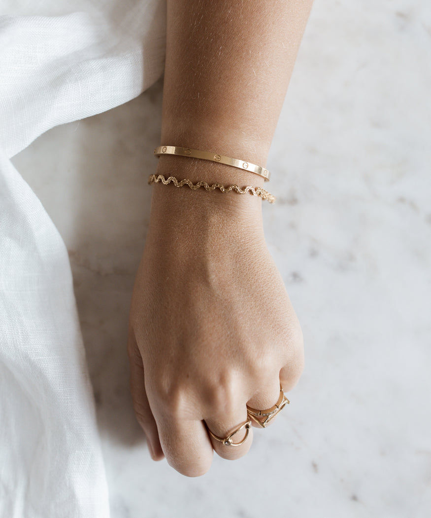 A woman wearing a WALD Berlin Irina Gold Bracelet and Ring.