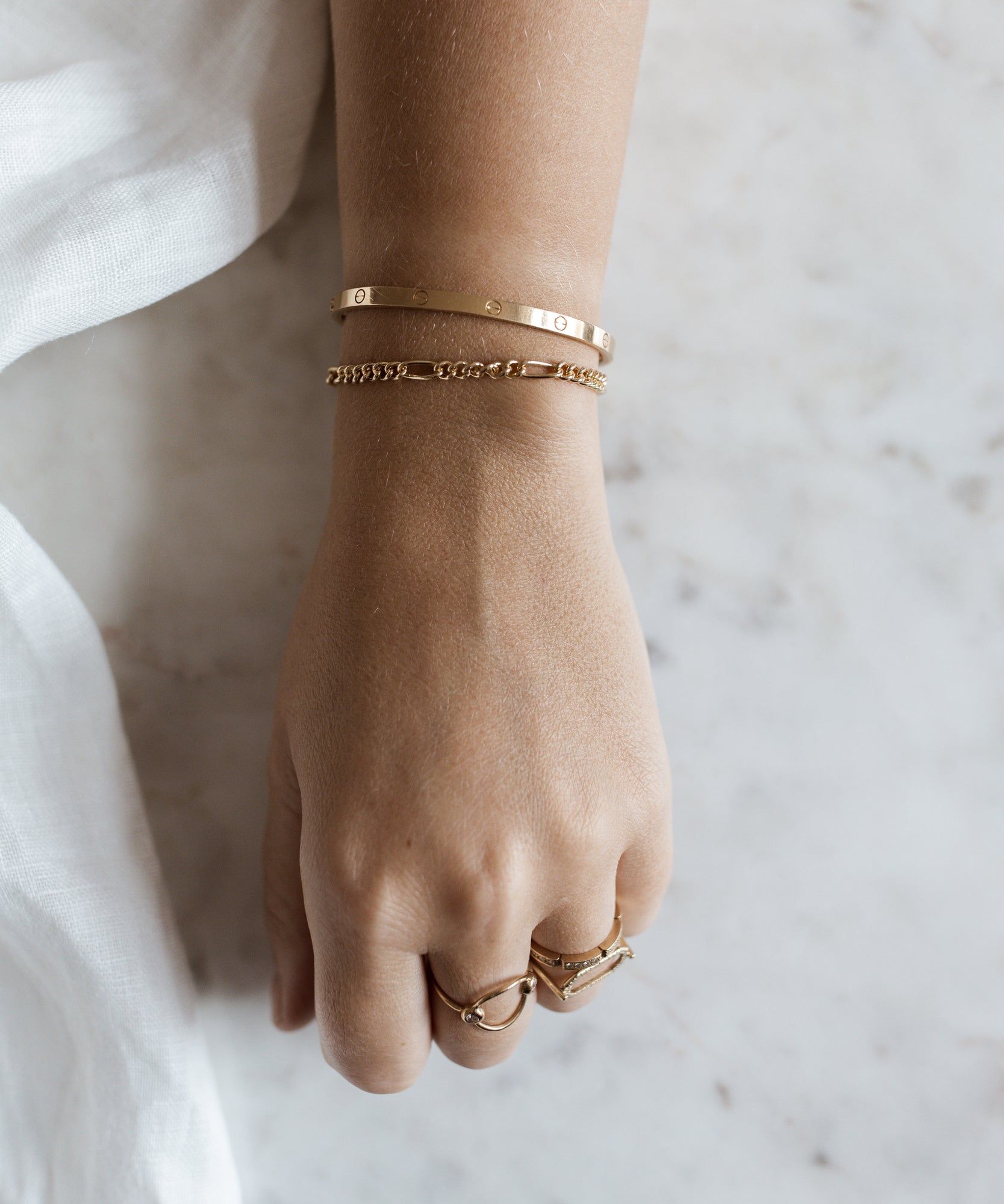 A woman's hand with the WALD Berlin Naomi Gold Bracelet and ring on it.