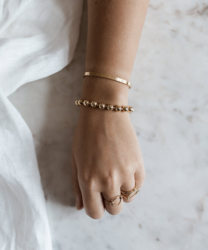 A woman's hand with a WALD Berlin Harry Gold Bracelet and ring on it.