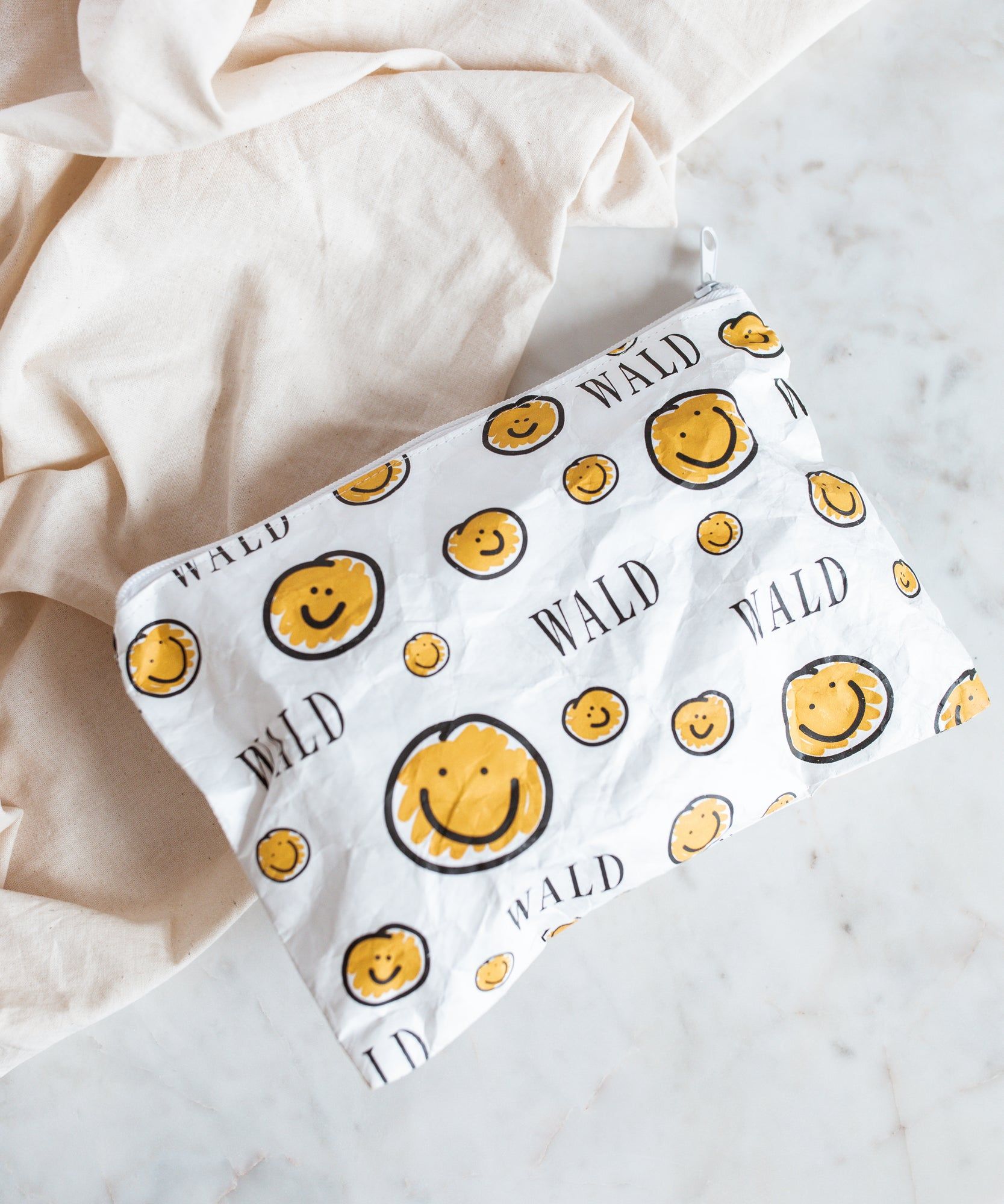 A Smilie Dude Pouch with a smiley face on it by WALD Berlin, a jewelry brand from Germany.