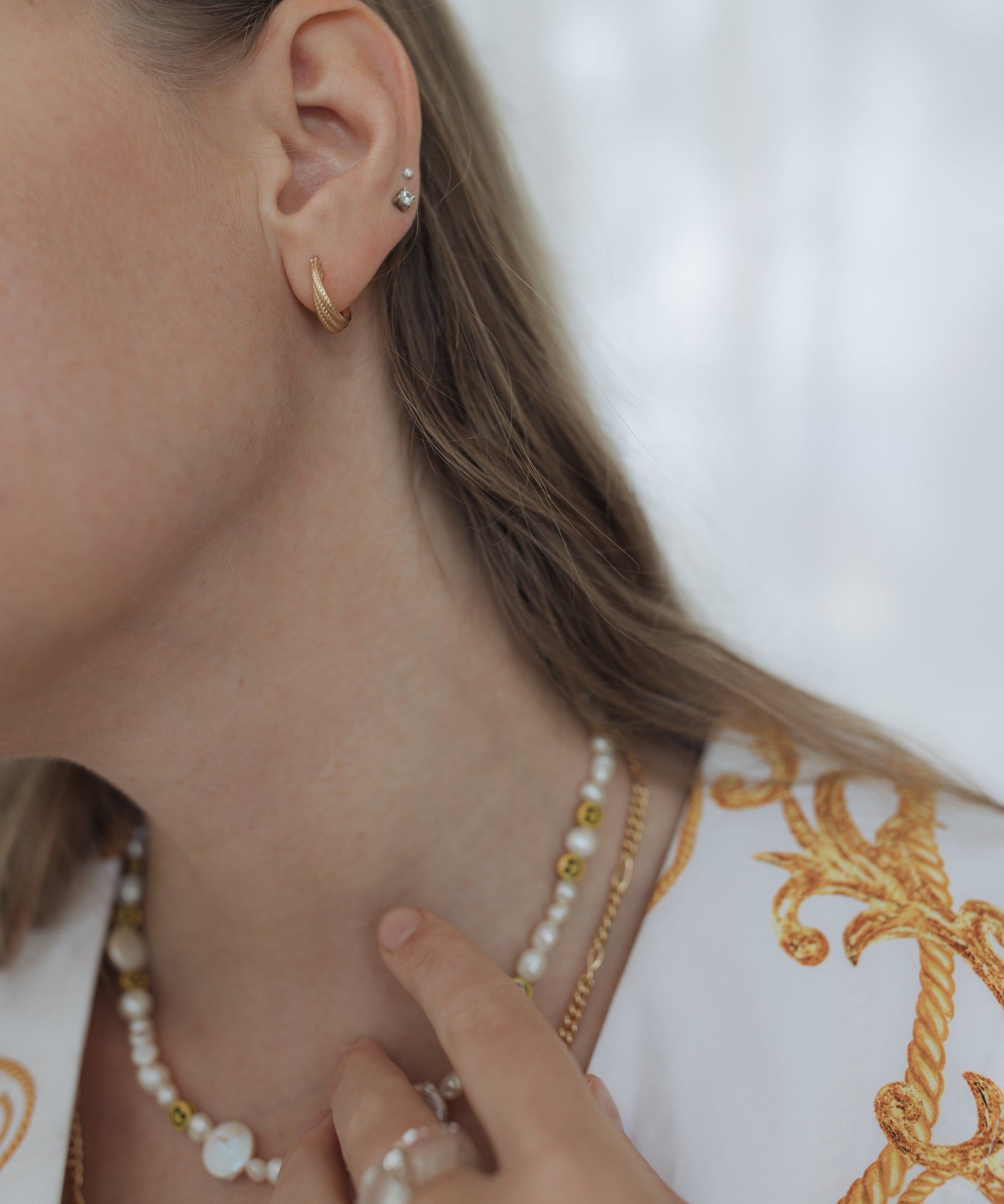 A woman wearing jewelry from WALD Berlin, including a Smilie Dude Pearl Necklace, in Germany.