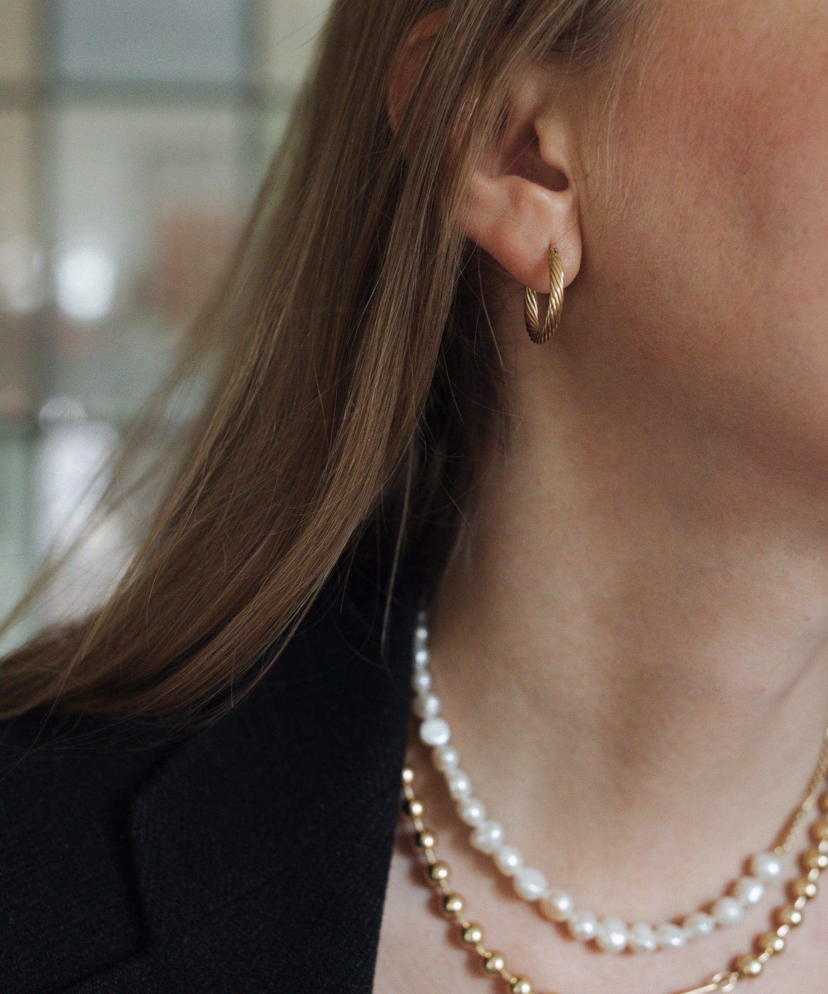 A woman wearing a black jacket and WALD Berlin's Pas De Deux Necklace.