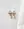 Happy Holidays Bow Earrings by WALD Berlin displayed on a marble surface, partially covered by a white cloth on the right side.