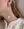 A person wearing WALD Berlin's Happy Holidays Pearl Drop Earrings and a cream knit sweater.