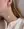 A person wearing WALD Berlin's Happy Holidays Pearl Drop Earrings and a cream knit sweater.