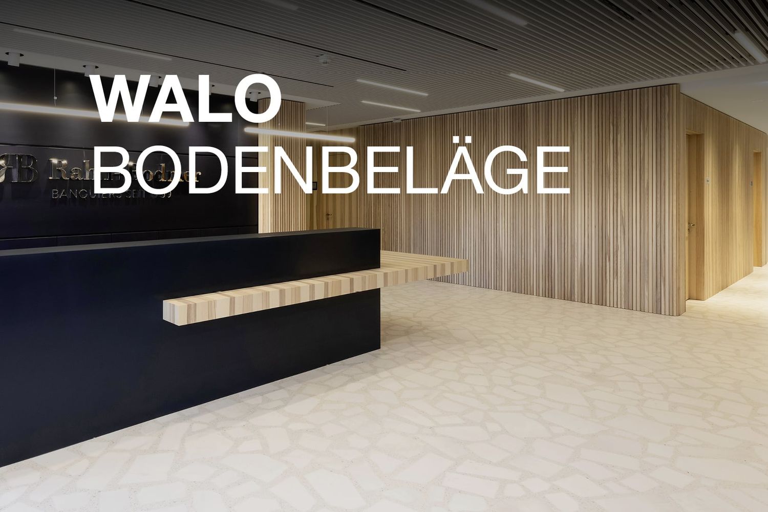 Moderner Eingangsbereich mit hellem, fugenlosem Bodenbelag im Terrazzo-Stil von WALO, kombiniert mit Holzverkleidung und dunklem Empfangstresen.