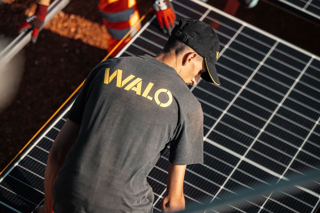 A technician in a black T-shirt and black cap with a yellow  A technician in a black T-shirt and black cap with a yellow