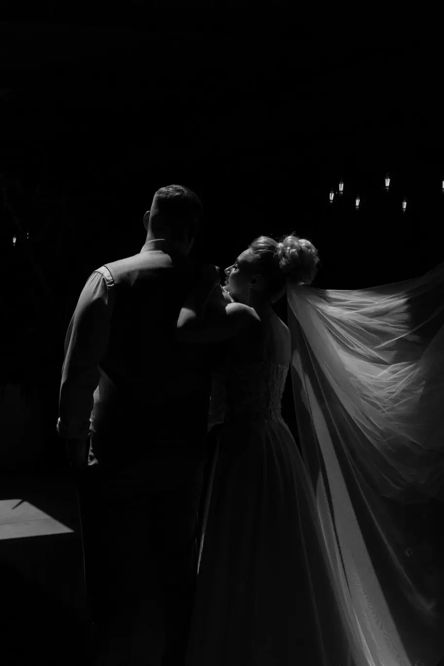 A couple dancing in the dark, backlit with only their silhouettes visible.