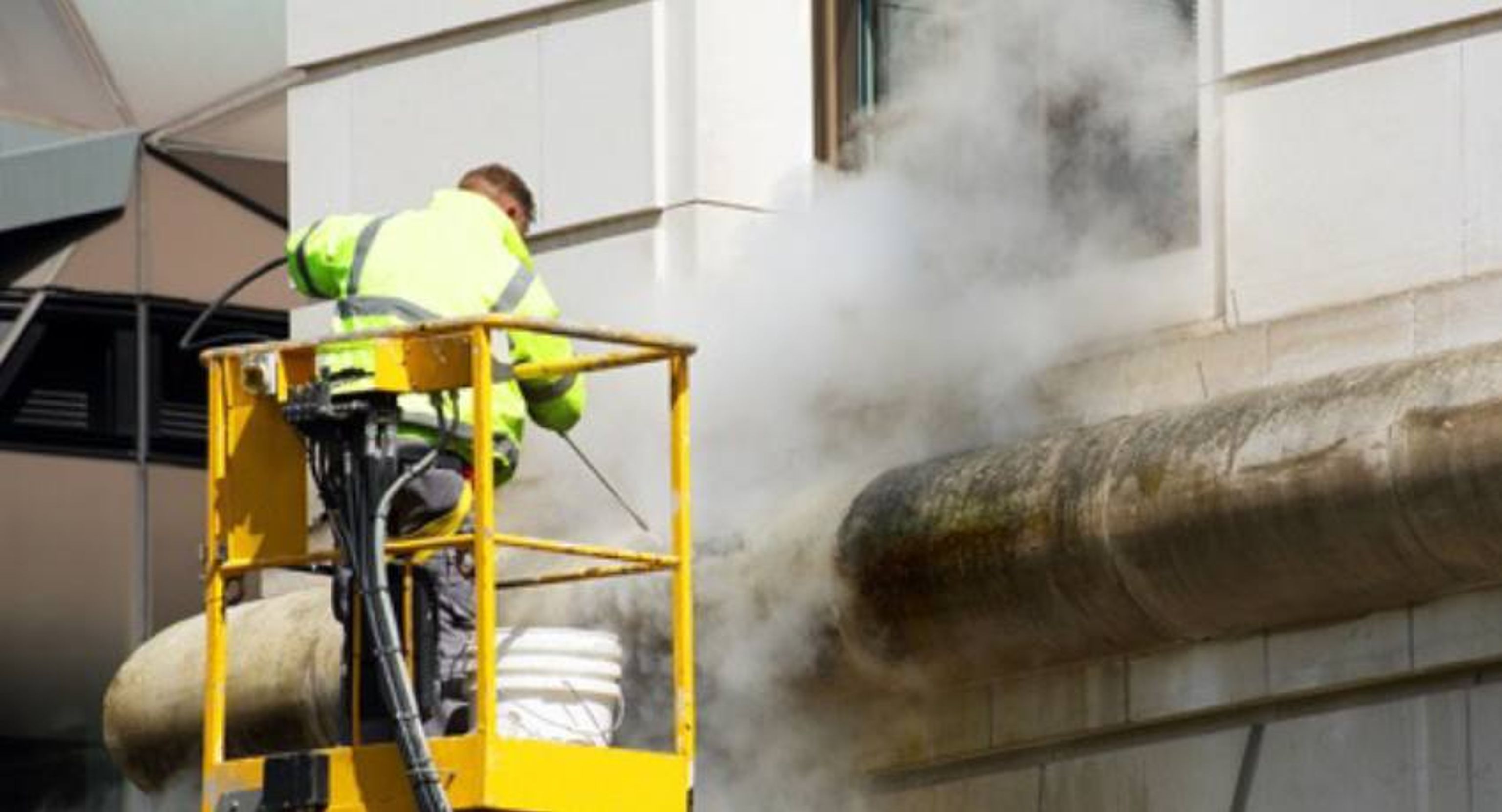 De juiste techniek voor het reinigen van een gevel met een hogedrukreiniger: demonstratie van correcte afstand, hoek en bewegingspatroon.