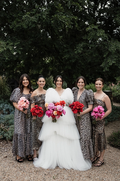 The wedding party in show-stopping dresses and bright bouquets