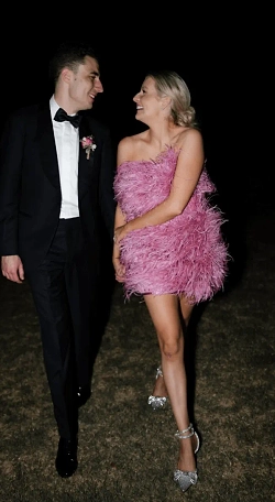 Couple entering their wedding reception, bride wears a pink feathery dress