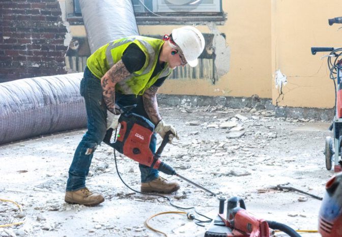 Weigand laborer operating a demolition hammer on a job site