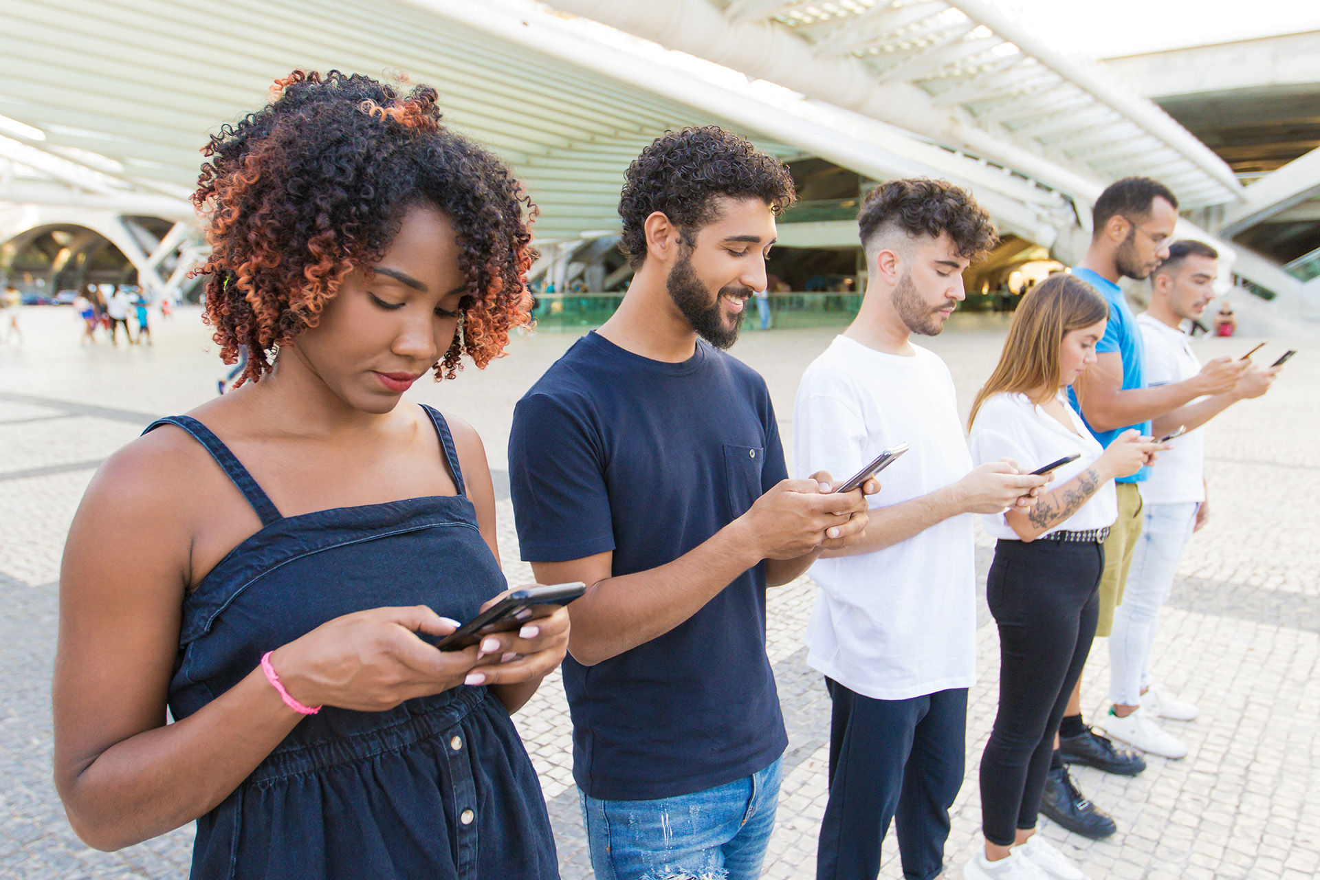 6 jovens um ao lado do outro mexendo em seus respectivos celulares utilizando Hotspot WiFi