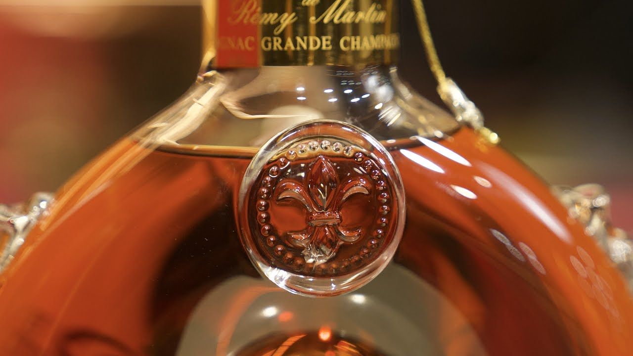 路易十三酒瓶的水位線示意圖，從理想的頸部到可能折價的中肩，展示水位對回收價的影響。