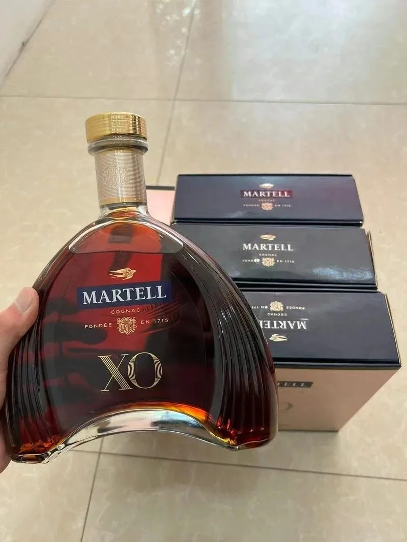 手持馬爹利 XO 酒瓶,後方放有馬爹利包裝盒