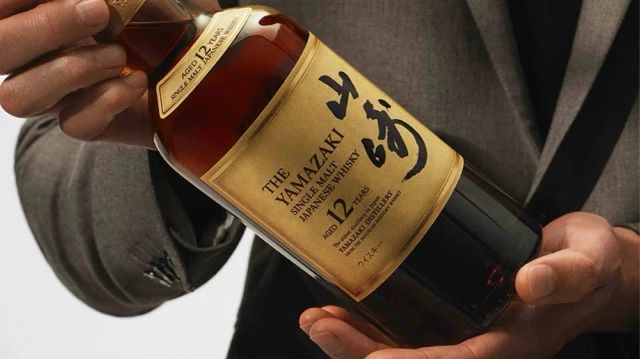 雙手托住山崎12年字標酒瓶的正面照片