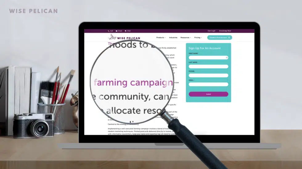 A laptop with a magnifying glass that enlarges the words 'farming campaign', representing keywords for SEO in real estate.