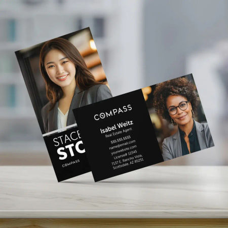 Horizontal Compass real estate business card with a laptop and a note book in the background.