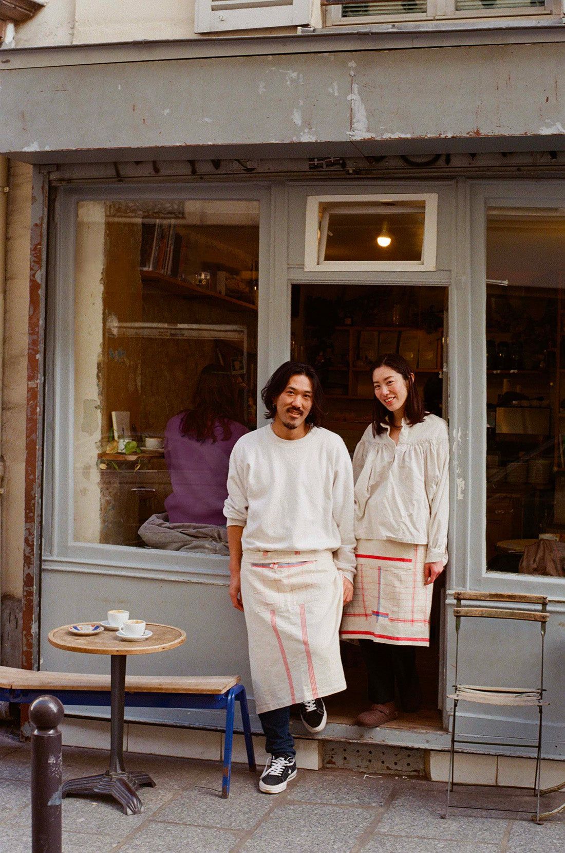 Two people in aprons outside their café