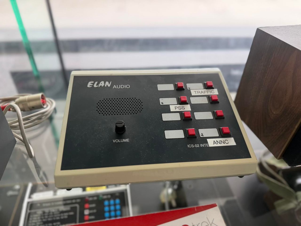 Black and beige audio control panel with red and gray buttons