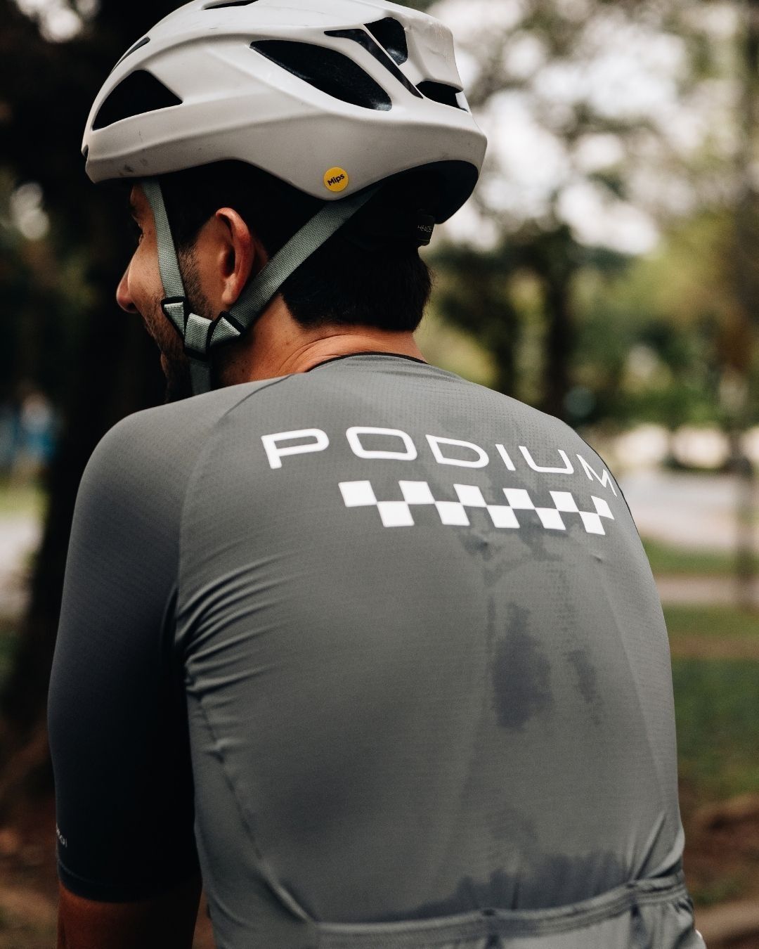 Victor Fonte Boa de capacete e camisa de ciclismo cinza com a marca Podium nas costas.