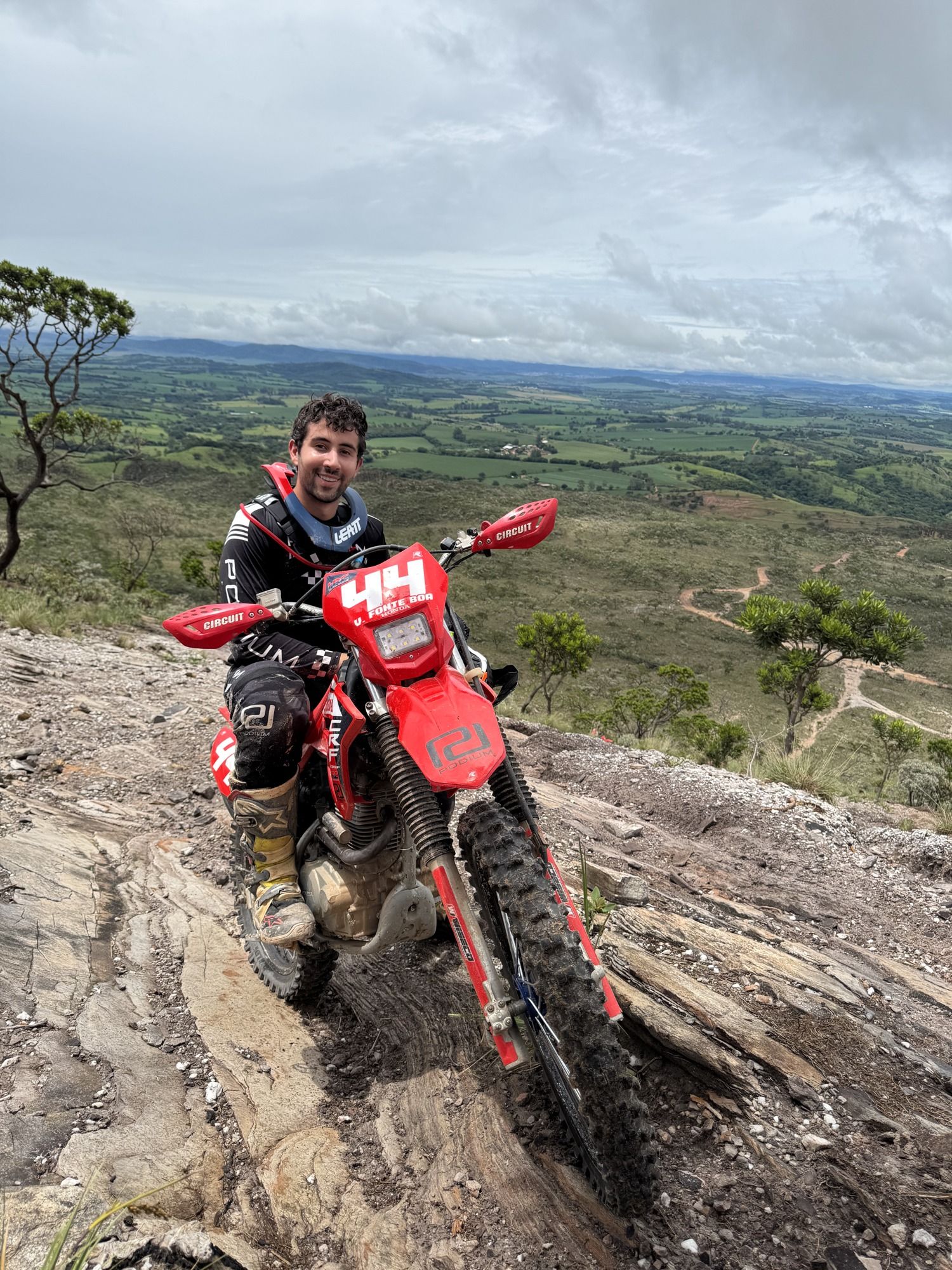 Victor Fonte Boa com sua moto em uma paisagem de montanhas.