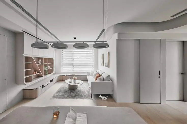 This may contain: a living room filled with furniture and lots of white walls on top of wooden floors