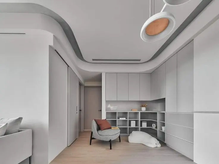 This may contain: the interior of a modern apartment with white walls and wood flooring, along with gray furniture