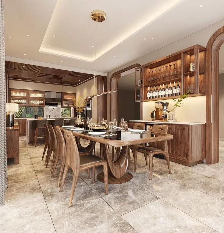 This may contain: a large dining room table surrounded by wooden chairs and an island with wine bottles on it