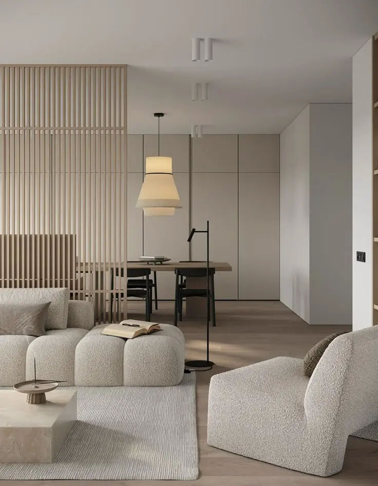 This may contain: a living room filled with white furniture next to a table and lamp on top of a hard wood floor