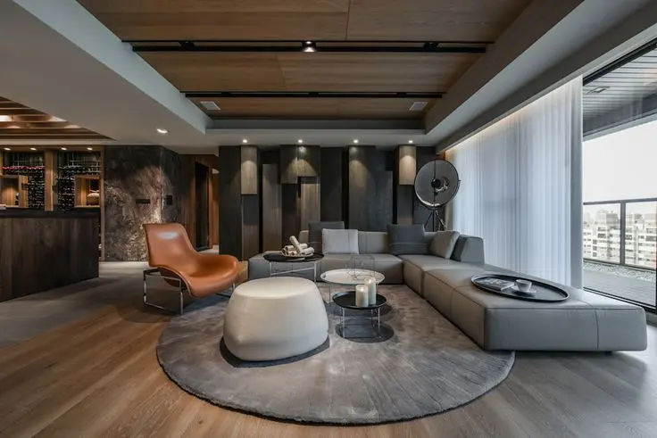 This may contain: a modern living room with large windows and wooden flooring on the walls, along with an l - shaped sectional sofa