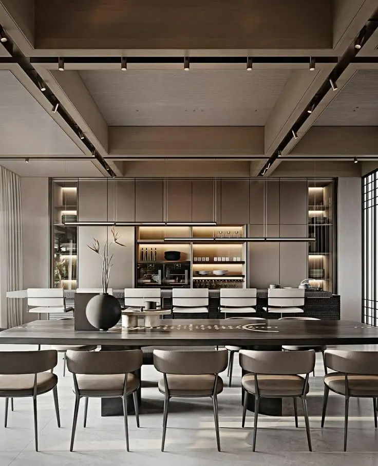 This may contain: a large dining table surrounded by chairs in a room with lots of windows and lighting