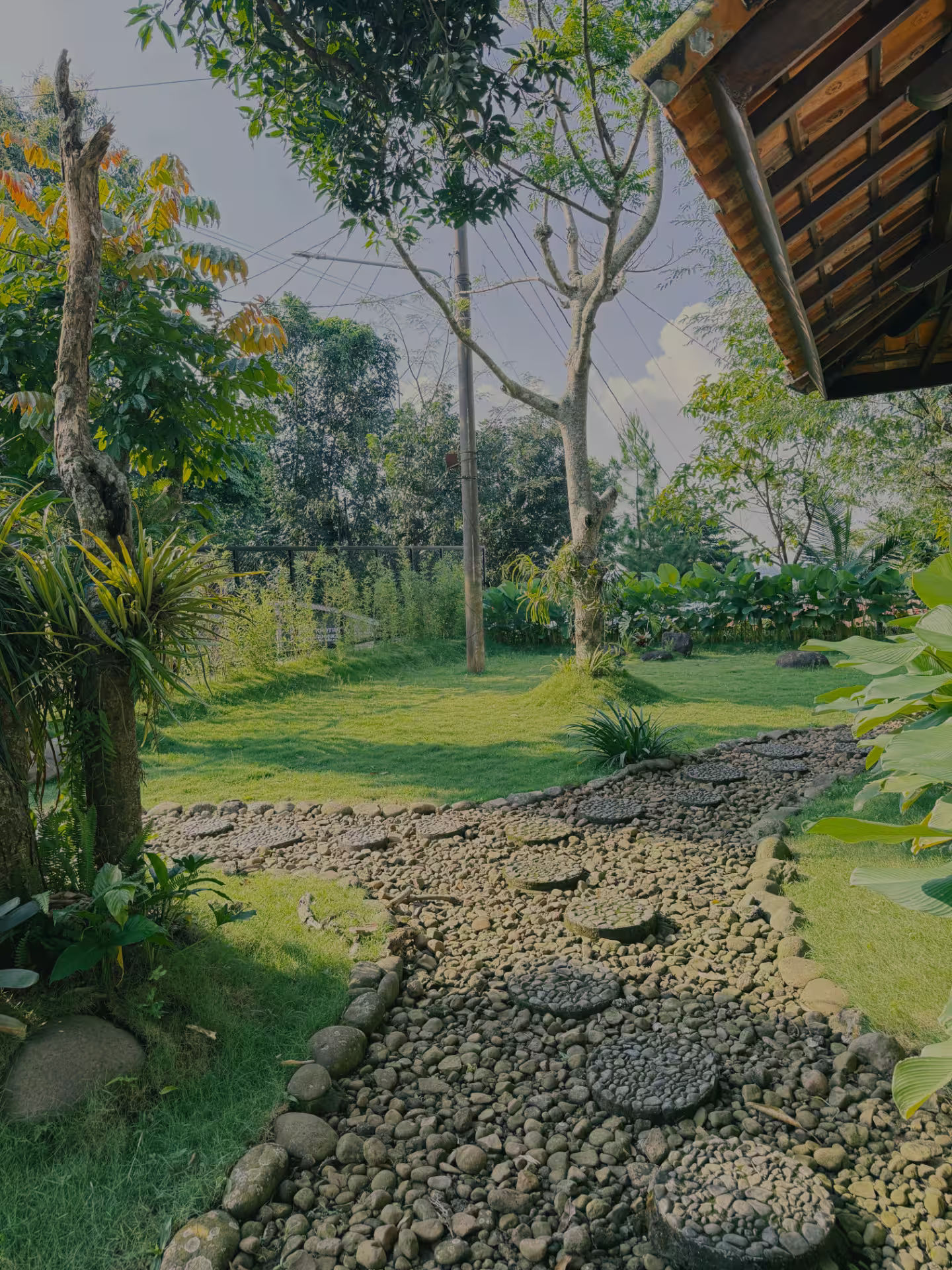 Pathway batu terbuka di area outdoor dirumahdelima dengan nuansa organik