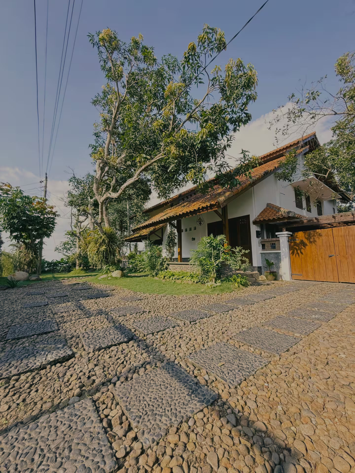 Sisi fasad dirumahdelima dengan material batu alami yang organik