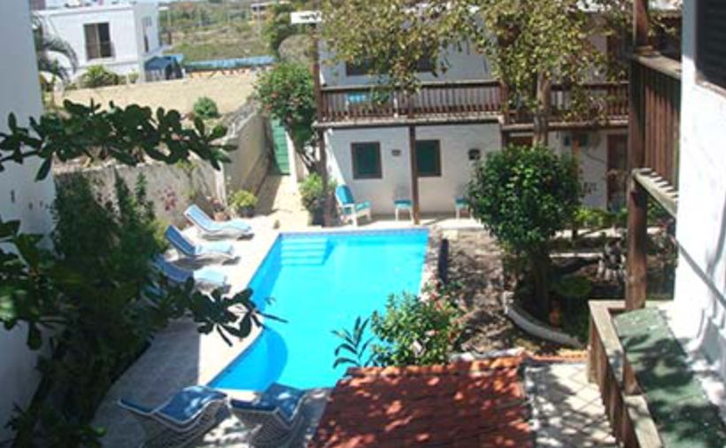 Letrero azul de Neptuno Refugio Condominio frente a un edificio blanco moderno en Boca Chica