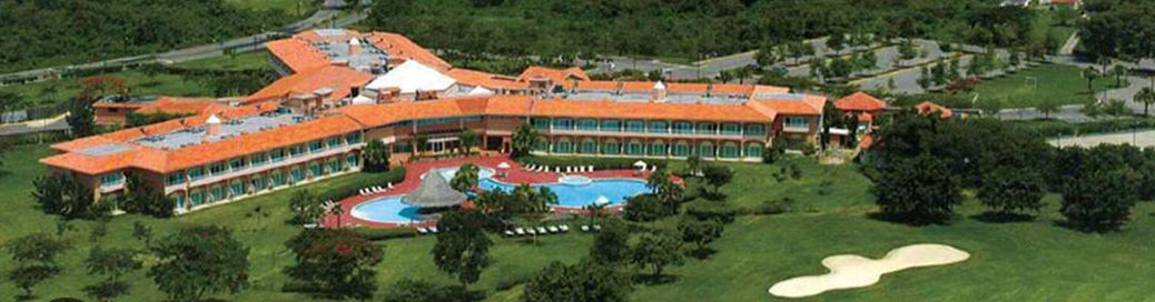 Vista aérea del hotel Hodelpa Garden Suites en Juan Dolio, mostrando su piscina de forma libre, áreas verdes y parte del campo de golf adyacente.