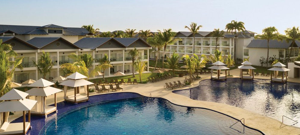 Vista aerea de Hilton La Romana An All-Inclusive Resort con piscina tropical, palmeras y el mar Caribe de fondo - Aerial view of Hilton La Romana resort