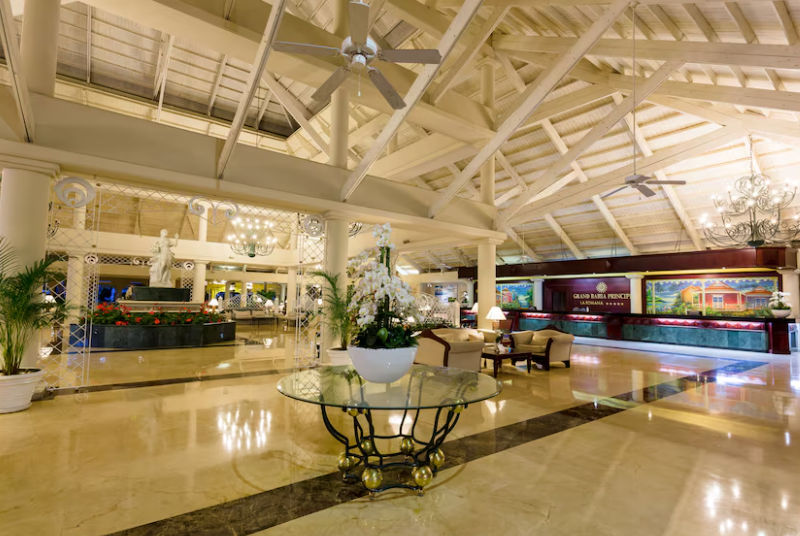 Main lobby and reception area at Bahia Principe hotel in La Romana featuring high wooden ceilings and tropical decor.