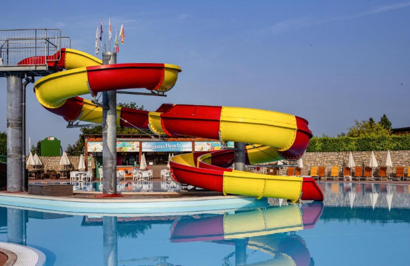 Vista aérea de un complejo turístico con piscina, zonas verdes y villas residenciales