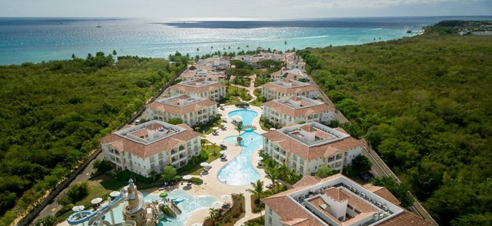 Vista aérea del complejo Miranda Bayahibe con sus edificios de villas, piscinas centrales y el mar Caribe al fondo.