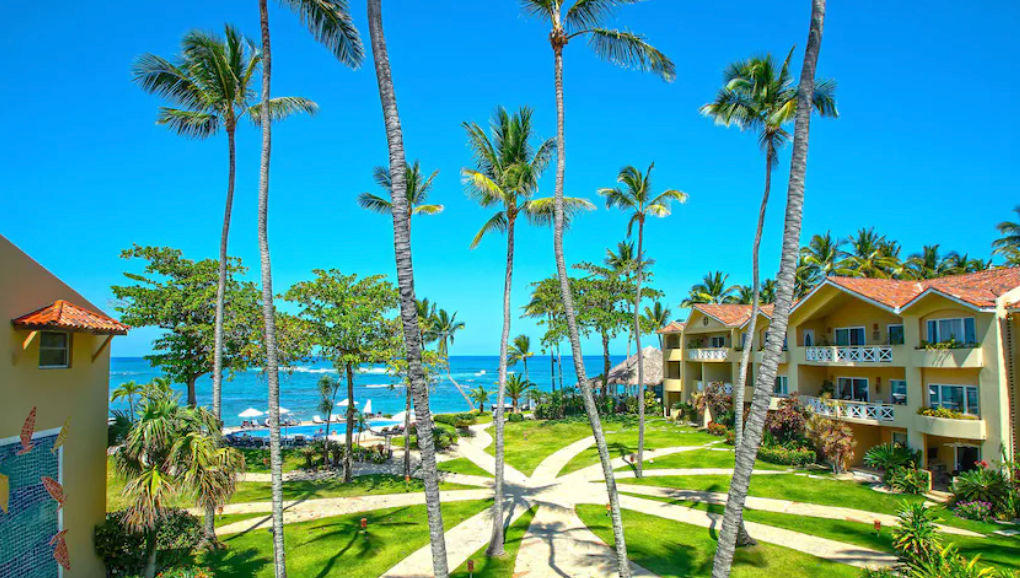 Vista panorámica de las instalaciones de Velero Beach Resort con palmeras, jardines, piscina y el mar de fondo en Cabarete