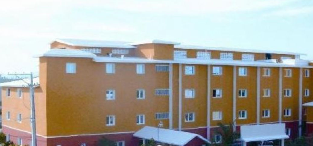 Exterior view of Hotel 2 Bávaro featuring a multi-story orange and dark red facade with white windows.